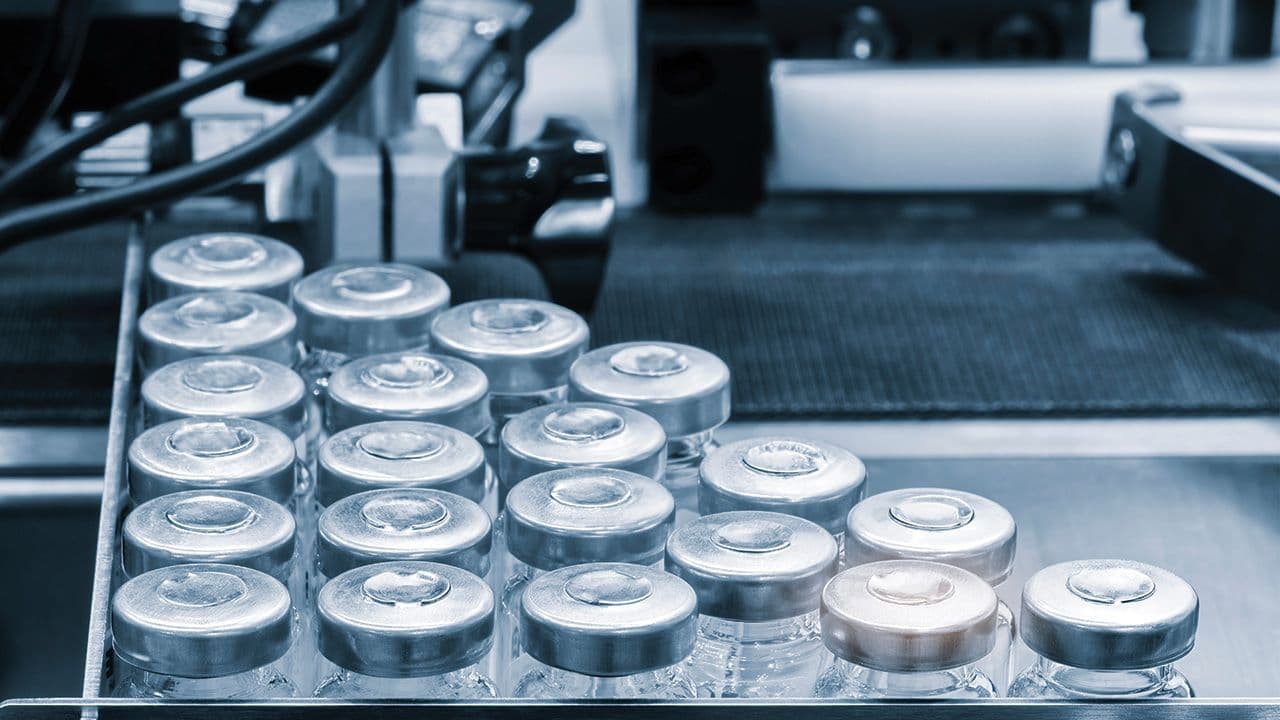 Pharmaceutical industry. Production line machine conveyor with glass bottles ampoules at factory. Pharmaceutical industry concept background. | Image Credit: © Aleksandr Matveev - © Aleksandr Matveev - stock.adobe.com