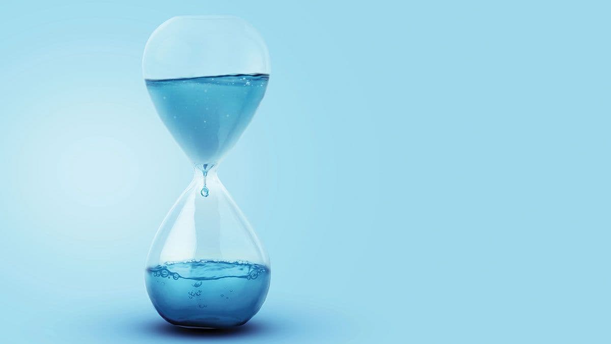 Time as water, a concept. Water with a drip dripping in a glass clock. Creative idea, save the water on a blue background. Global Warming | Image Credit: ©alones - stock.adobe.com